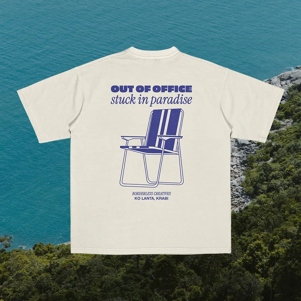 “Out of Office” t-shirt by Amici al Sole photographed in a tropical setting, symbolizing freedom and good vibes.