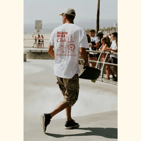 run-club-tshirt-lifestyle-amici-al-sole Lifestyle photo of “Run Club” t-shirt by Amici al Sole, worn while skateboarding by the beach.